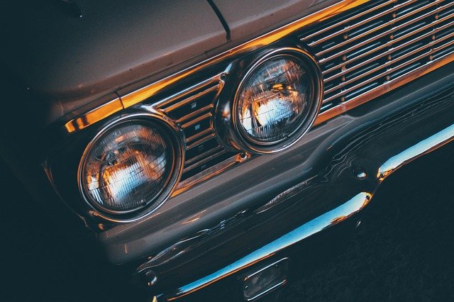 Close-up of vintage car headlights and chrome grille, highlighting classic car design details