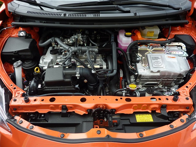 Close-up of engine bay in an orange car, vehicle maintenance, car engine components, automotive repair Close-up of engine bay in an orange car, vehicle maintenance, car engine components, automotive repair