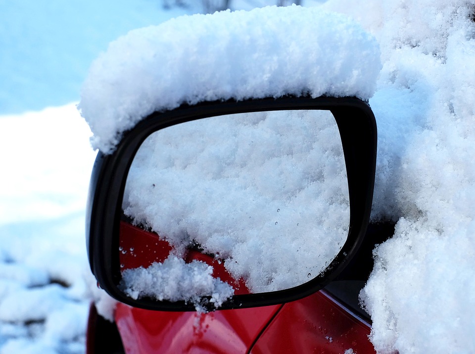Snow-covered car mirror: winter car care tips, preparing your car for snow, cold weather maintenance
