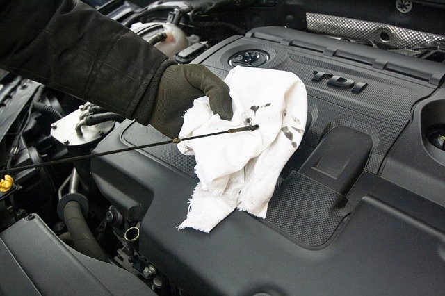 mechanic checking engine oil