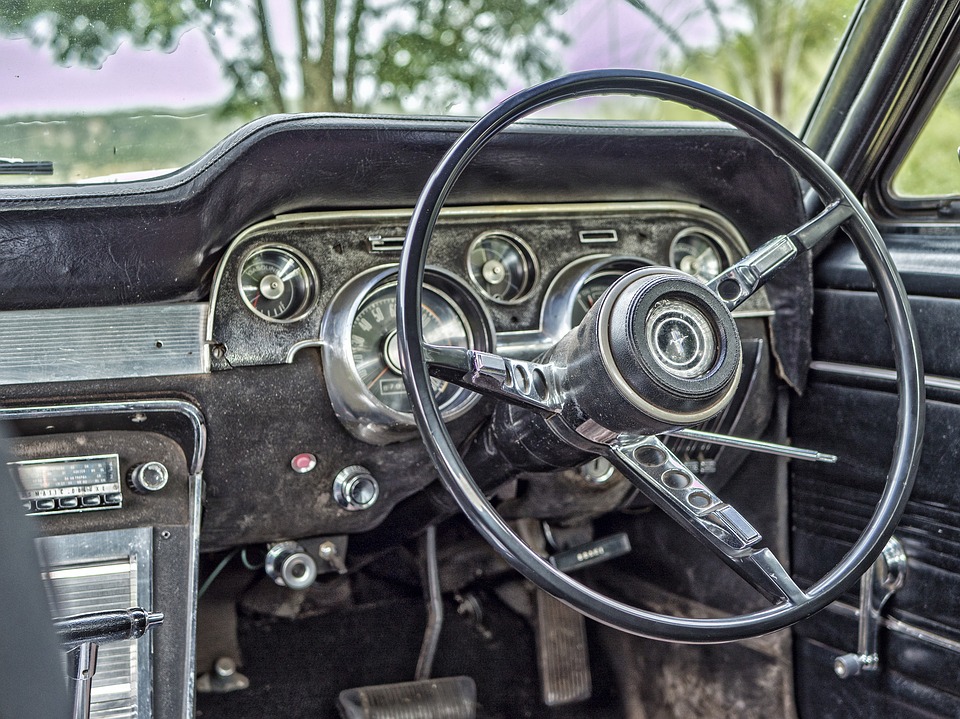 Interior of a vintage car with a classic steering wheel and dashboard, antique vehicle, retro car