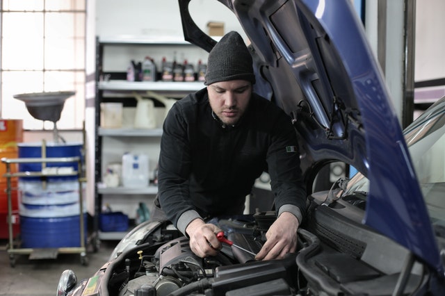 homme travaillant sur la pompe de direction assistée