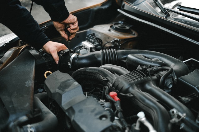 Mechanic working on a car engine, automotive repair, engine maintenance, vehicle service