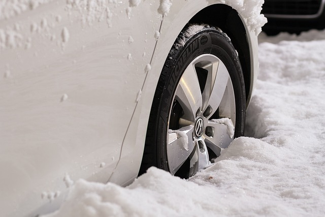 Car tire in snow, highlighting winter driving conditions, car in cold weather, and vehicle traction