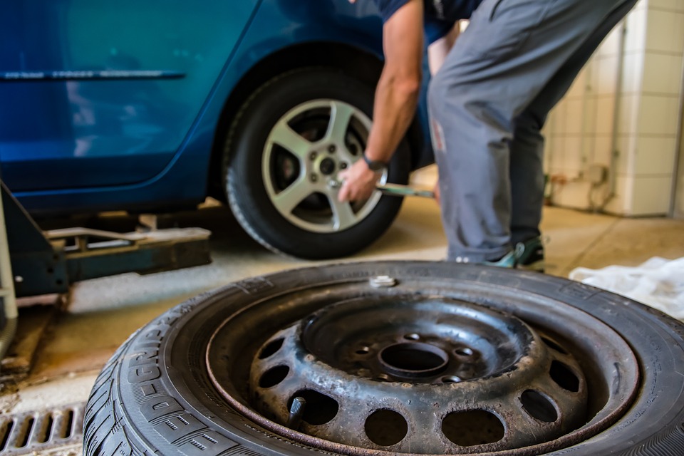 man changing car tire in shop